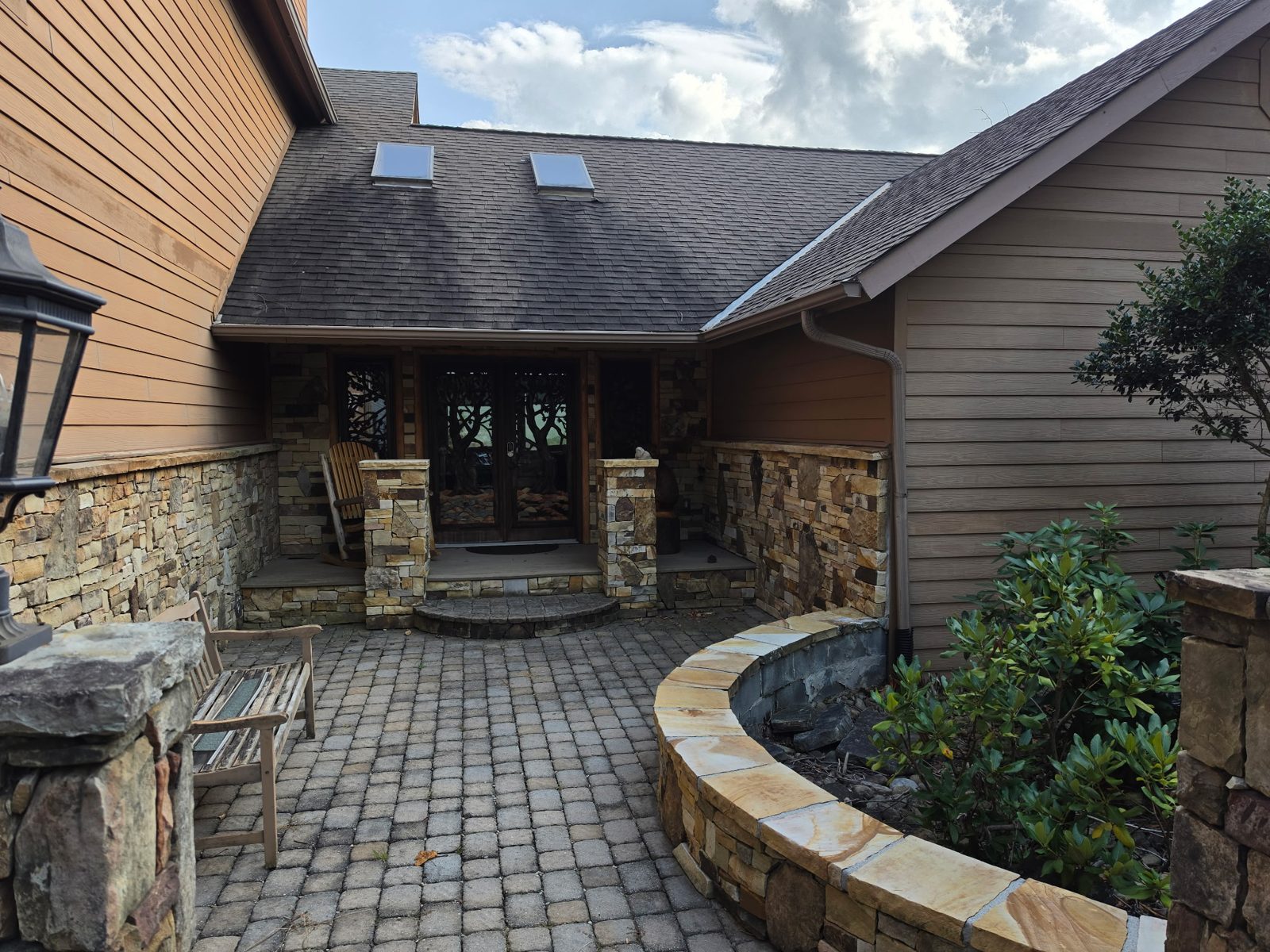 The cabin entry with a downspout beside the door.