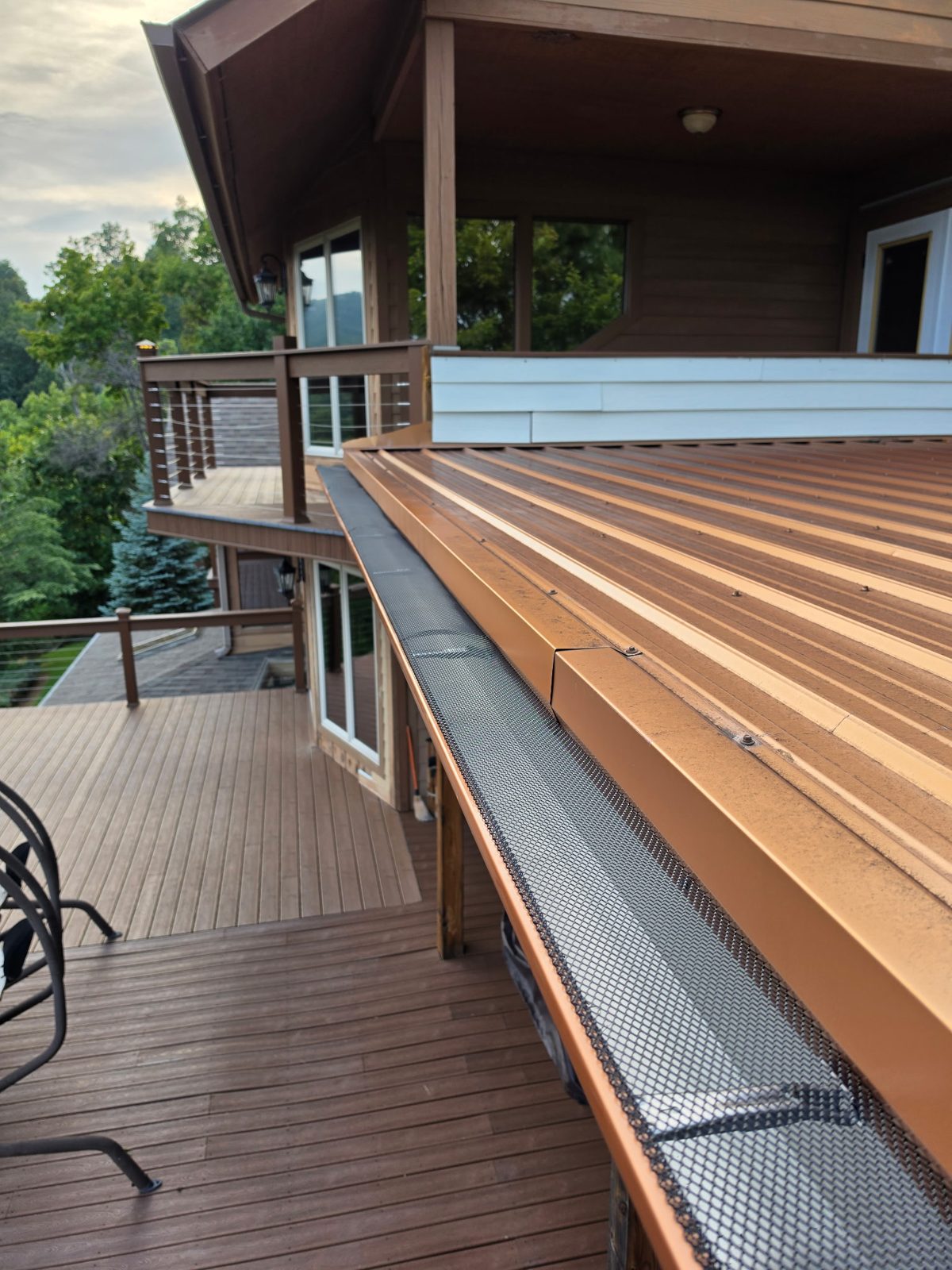 Close-up of a gutter and leaf guard along a metal roof over a deck in Gatlinburg, Tennessee.