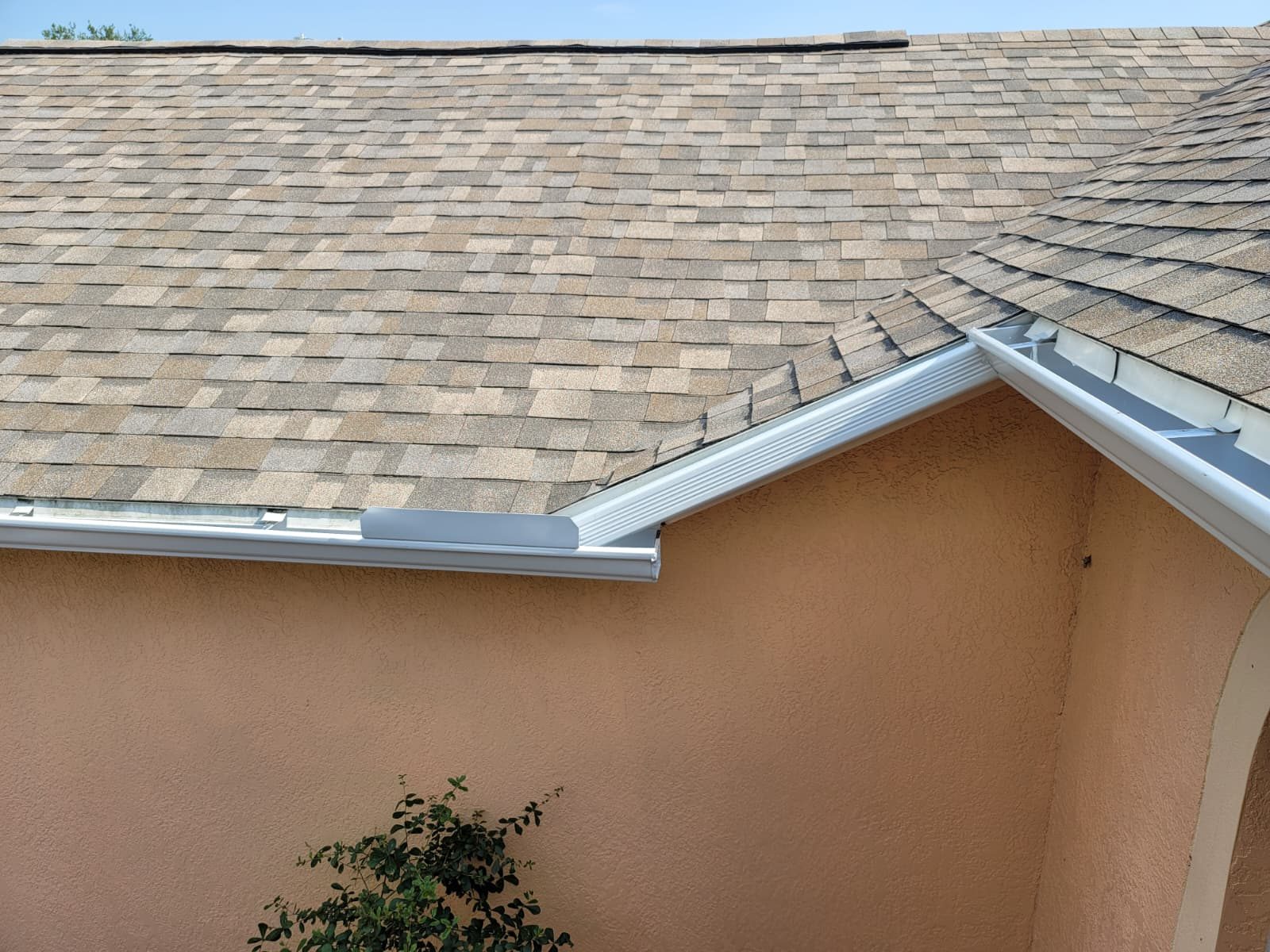 White seamless gutter under a tile roof.